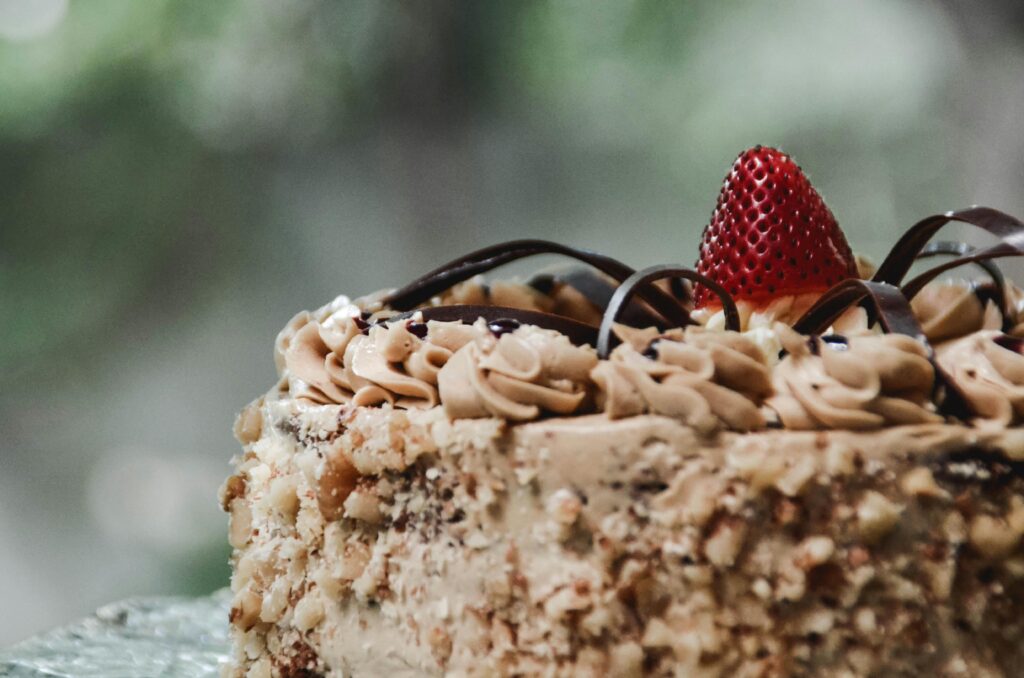 Close-up of a luxurious chocolate cake adorned with fresh strawberry and cream, eggless cake